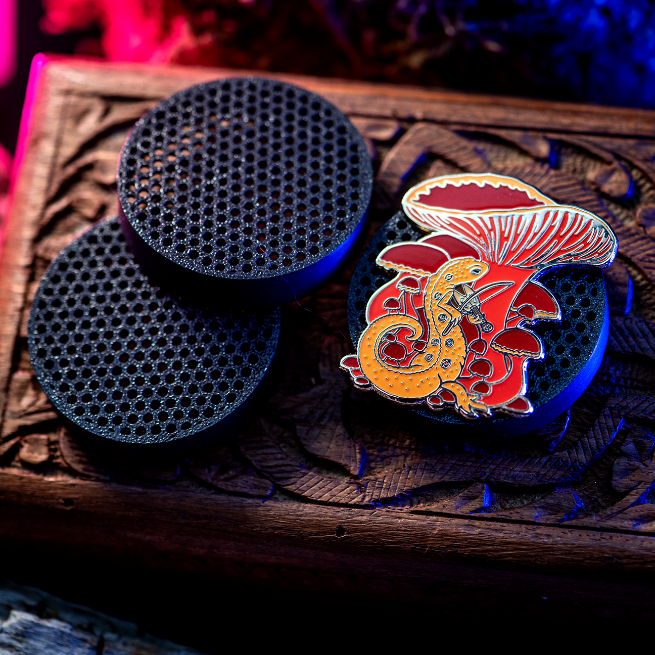 Tabletop game piece displaying a red eft enamel pin by The Roving House.