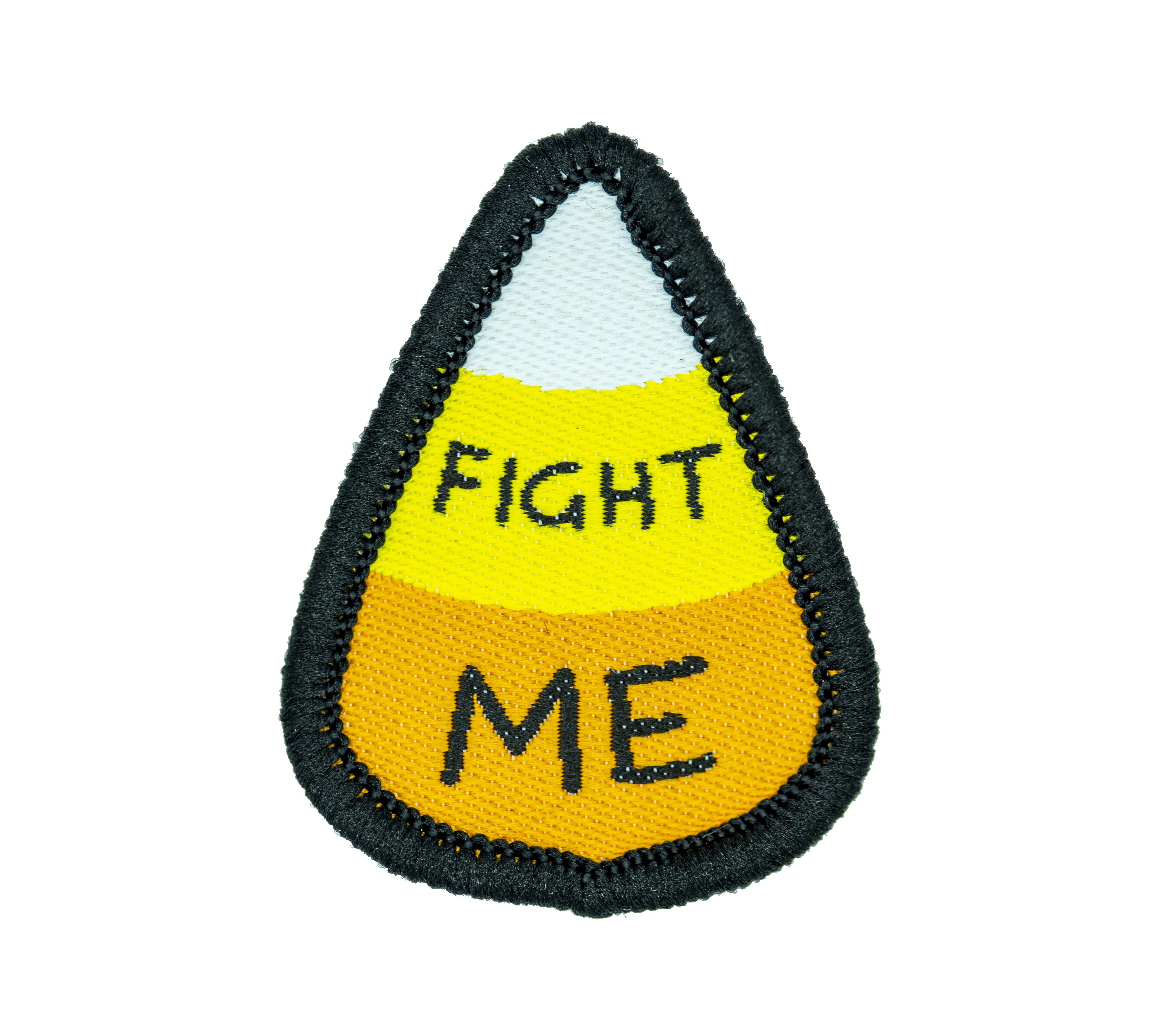 A small woven patch in the shape of a white, yellow, and orange candy corn, with black text reading "FIGHT ME".